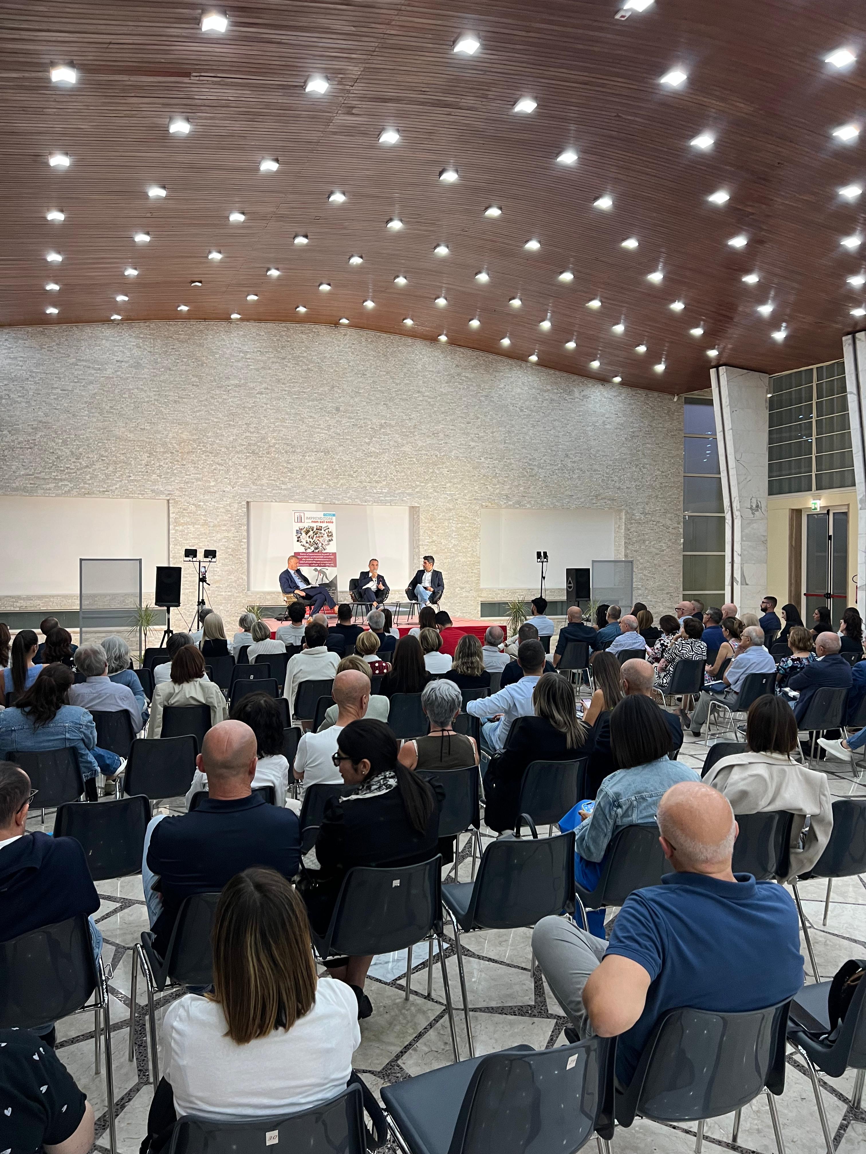 Talk sul palco con il banner di Imprenditore Non Sei Solo